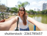 Portrait of happy Brazilian girl takes selfie in Vaca Brava Park in Goiania, Goias, Brazil