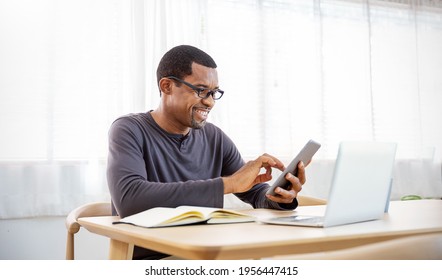 Portrait of happy business African black man with casual cloths working in home office desk using phone computer. Small business employee freelance online sme marketing e-commerce telemarket concept