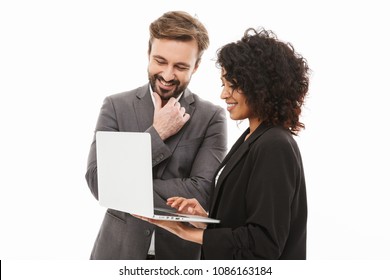 Portrait of a happy business couple looking at laptop computer isolated over white background