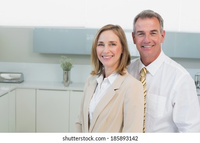 Portrait Of A Happy Business Couple Standing In The Kitchen At Home