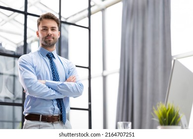 Portrait of happy businessman with arms crossed standing in office