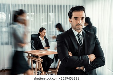 Portrait of happy businessman looking at camera with motion blur background of business people movement in dynamic business meeting. Habiliment - Powered by Shutterstock