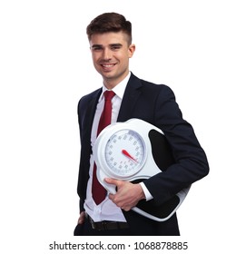 portrait of happy businessman promoting a healthy lifestyle while holding a scale, meaning that it is important to measure your weight periodically