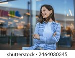 Portrait of happy businesswoman looking at camera. Successful proud woman in city street at sunset. Satisfied latin business woman in formal clothing smiling outdoors.