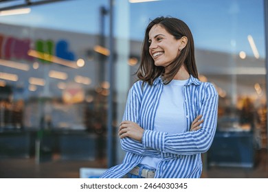 Portrait of happy businesswoman looking at camera. Successful proud woman in city street at sunset. Satisfied latin business woman in formal clothing smiling outdoors. - Powered by Shutterstock