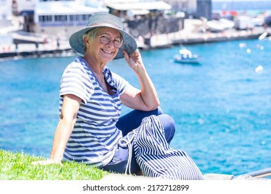 Portrait Of Happy Carefree Caucasian Senior Woman Sitting Outdoors At Sea Enjoying Summer Holidays. Horizon Over Water