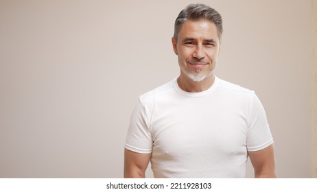 Portrait of happy casual older man smiling, Mid adult, mature age guy with gray hair, Isolated on white background, copy space.