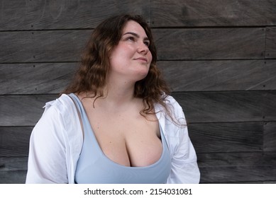Portrait happy caucasian attractive overweight girl in white shirt dreamily looking up