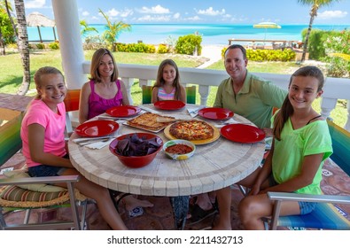 Portrait Of Happy Caucasian Family Having Lunch At Outdoor Beach Restaurant With Beautiful View By The Ocean Bahamas