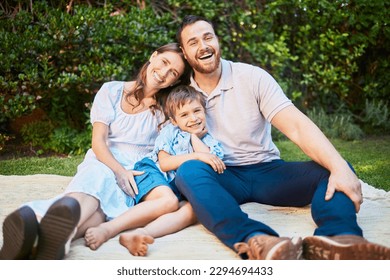 Portrait of a happy caucasian family having a picnic in their garden, sitting on a blanket. Cheerful parents relaxing, enjoying a summer day with their little son. Young family relaxing outside - Shutterstock ID 2294694433