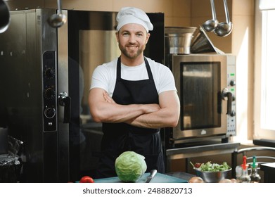 Portrait of happy caucasian male chef standing in restaurant kitchen, copy space. - Powered by Shutterstock