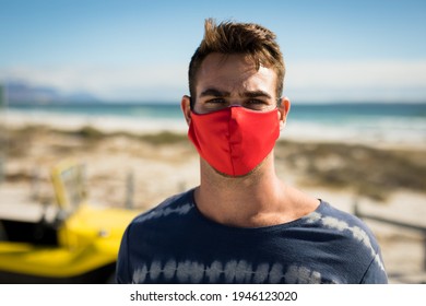 Portrait Of Happy Caucasian Man Wearing Face Mask Next To Beach Buggy Looking To Camera. Beach Stop Off On Summer Holiday Road Trip During Coronavirus Covid 19 Pandemic.