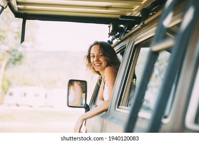 Portrait Happy Caucasian Woman Drives A Old Vintage Camper Van Or RV On Road. Family Travel Vacation And Holiday Trip.