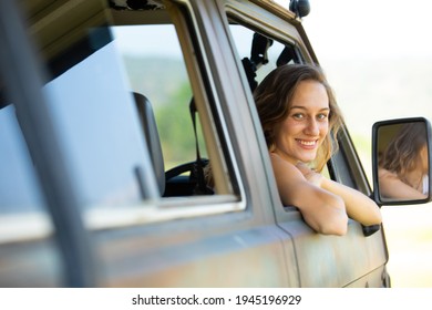 Portrait Happy Caucasian Woman Drives A Old Vintage Camper Van Or RV On Road. Family Travel Vacation And Holiday Trip.