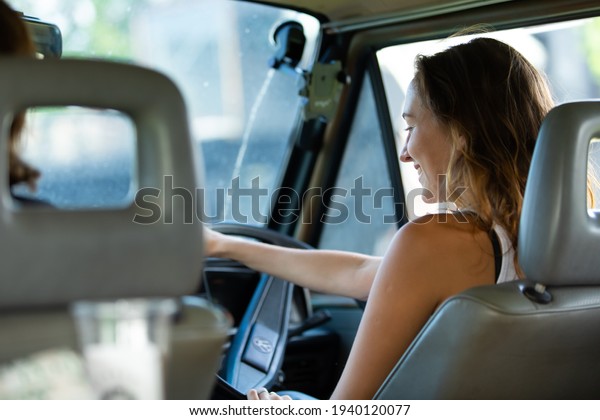 Portrait happy\
caucasian woman drives a old vintage camper van on road. Family\
travel vacation and holiday\
trip.