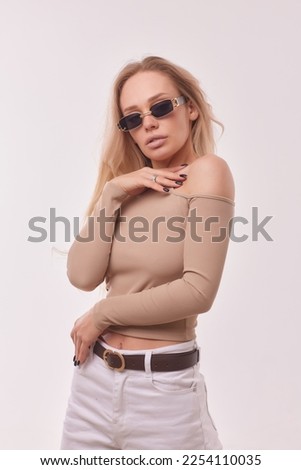 Portrait of happy charming cheerful blonde young girl, smiles, looking happy and glad, lively, with natural make-up, tanned, dressed in casual long sleeve t-shirt