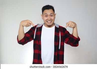 Portrait Of Happy Cheerful Asian Man Surprised And Pointing Down Over Grey Background