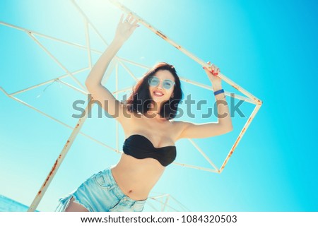 Portrait of happy cheerful beautiful woman in bikini and shorts with good body smiling and enjoying summer on the beach. Holidays Vacation Lifestyle Recreation concepts