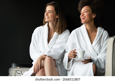 Portrait of happy cheerful girl in robe talking with her friend
