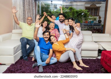 Portrait of Happy cheerful indian joint family sitting together at home. Asian senior and young couple with their kids having and laughing. - Powered by Shutterstock