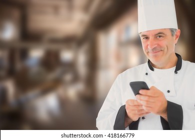 Portrait of happy chef holding cell phone against large vats of beer - Powered by Shutterstock