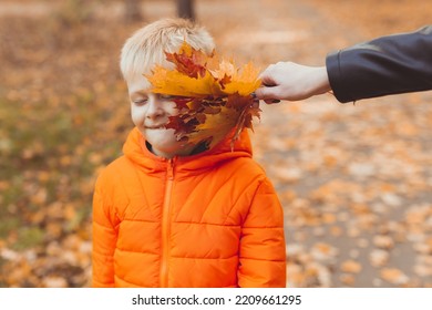 Portrait Of Happy Child Boy In Orange Jacket In Autumn Park. Fall Season And Children Concept