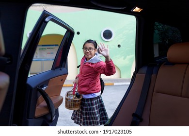 Portrait Of A Happy Child Withbackpack On His Back Move Her Hand After Get Off Car. Student Going To School And Waving My Parent Goodbye. Happy Student Girl Go To School Family In Car Concept,