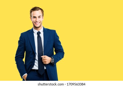 Portrait of happy confident businessman in blue suit and tie, isolated against yellow color background. Business success concept. Smiling man at studio picture. Copy space for some text or slogan.