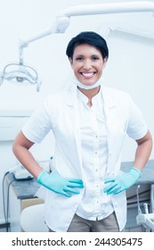 Portrait Of Happy Confident Female Dentist With Hands On Hips