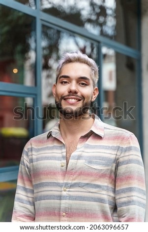 Portrait of happy confident young man with trendy casual wear looking to the camera. Handsome gay man with eye make up on his face. Gender fluid, lgbt and diversity concept 
