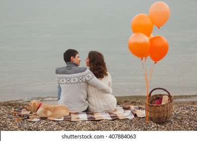 portrait of the happy couple on the beach, river or lake. Cloudy autumn, but they came to the picnic with a dog Labrador puppy. Family happiness, an exemplary family, honeymoon or youth - Powered by Shutterstock