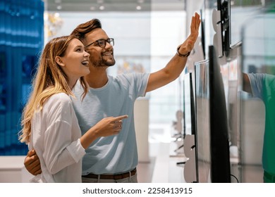 Portrait of happy couple shopping in a tech store. Technology people smart device concept - Powered by Shutterstock