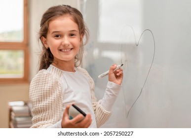 Portrait Of A Happy Cute Child Student Who Writing With A Marker On The Modern Smart Whiteboard. Selective Focus