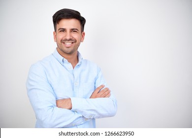 Portrait Of Happy Dark Haired Man Wearing Blue Shirt Standing With Arms Crossed On White Background