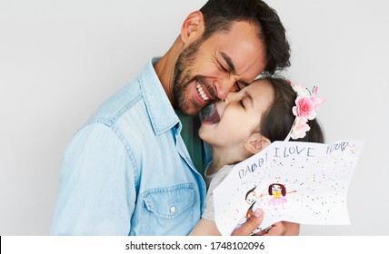 Portrait happy daughter giving drawing greeting card for his happy handsome father Father's day  Loving daddy   his little girl enjoying time together  Fatherhood   childhood concept 