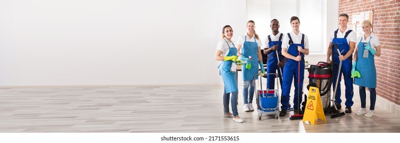 Portrait Of Happy Diverse Janitors In The Office With Cleaning Equipment