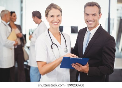 Portrait Of Happy Doctors With Clipboard In Hospital