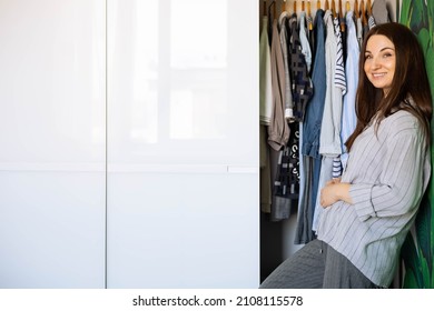 Portrait Of Happy Domestic Woman Posing Hiding Inside Mirror Cupboard Door With Wardrobe Comfortable Storage Organization. Wooden Furniture Cabinet Decorative Design. Furnishing Home Interior