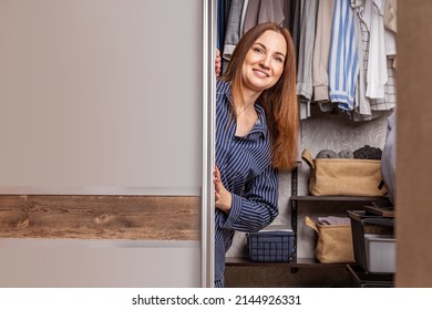 Portrait Of Happy Domestic Woman Posing Hiding Inside Mirror Cupboard Door With Wardrobe Comfortable Storage Organization. Wooden Furniture Cabinet Decorative Design. Furnishing Home Interior