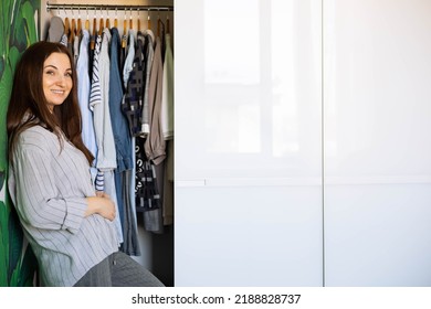 Portrait Of Happy Domestic Woman Posing Hiding Inside Mirror Cupboard Door With Wardrobe Comfortable Storage Organization. Wooden Furniture Cabinet Decorative Design. Furnishing Home Interior