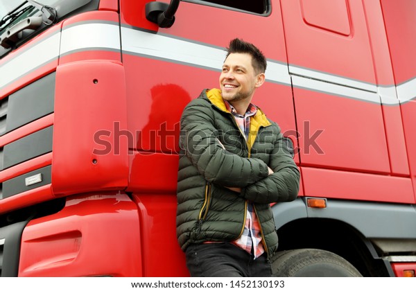 Portrait of\
happy driver at modern truck\
outdoors