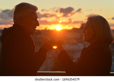 Portrait Of Happy Elderly Couple Holding Hands At Tropical Beach At Sunset