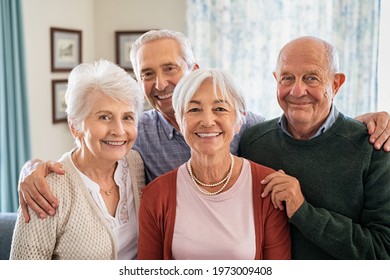 Portrait of happy elderly people looking at camera at care centre. Cheerful senior man and beautiful old woman embracing. Smiling seniors standing together with a big grin on their faces.