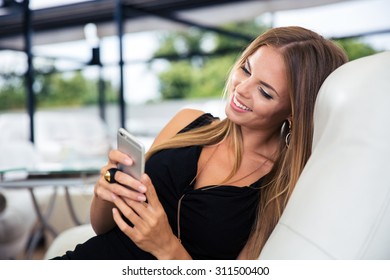 Portrait of a happy elegant woman in black dress using smartphone - Shutterstock ID 311500400