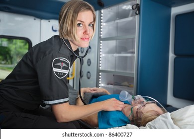 Portrait of a happy EMT worker inside ambulance tending to senior woman patient - Powered by Shutterstock