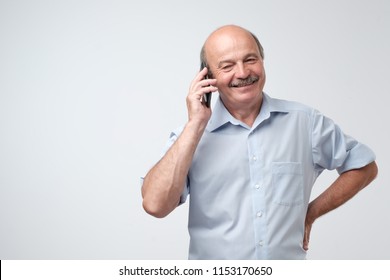 Portrait of happy european senior man talking on phone and smiling. Reach an agreement with partner on work. Call your father concept