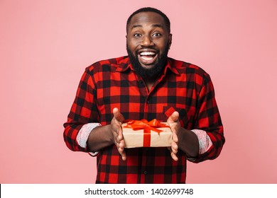 Portrait Of A Happy Excited African Man Wearing Shirt Standing Isolated, Showing Present Box