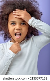 Portrait Of Happy Excited Amazed Open Mouth Kid Child Girl Look In Copyspace Isolated On Purple Color Background. Cheerful Curly Black Kid In White Shirt Is Surprised. Children And Human Emotions