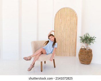 Portrait Of A Happy Excited Emotional Girl In A Blue Plain Dress In A Light Interior 