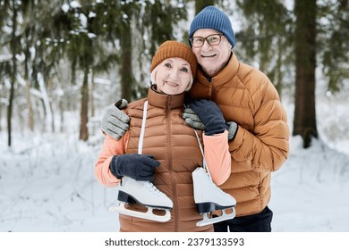 Portrait of happy excited senior couple with ice skates standing in city park - Powered by Shutterstock